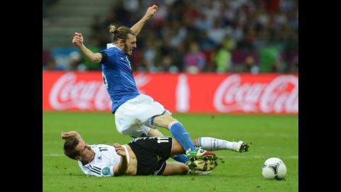 German forward Miroslav Klose lands on the ground while vying with Italian defender Federico  Balzaretti.