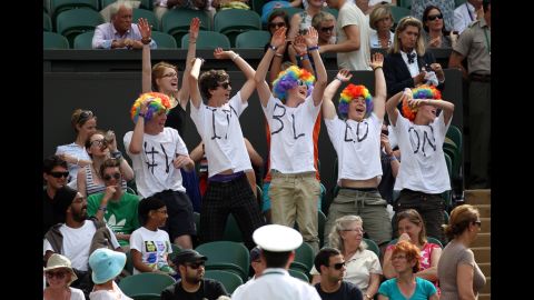 Tennis spectators cheer in colorful wigs June 28.