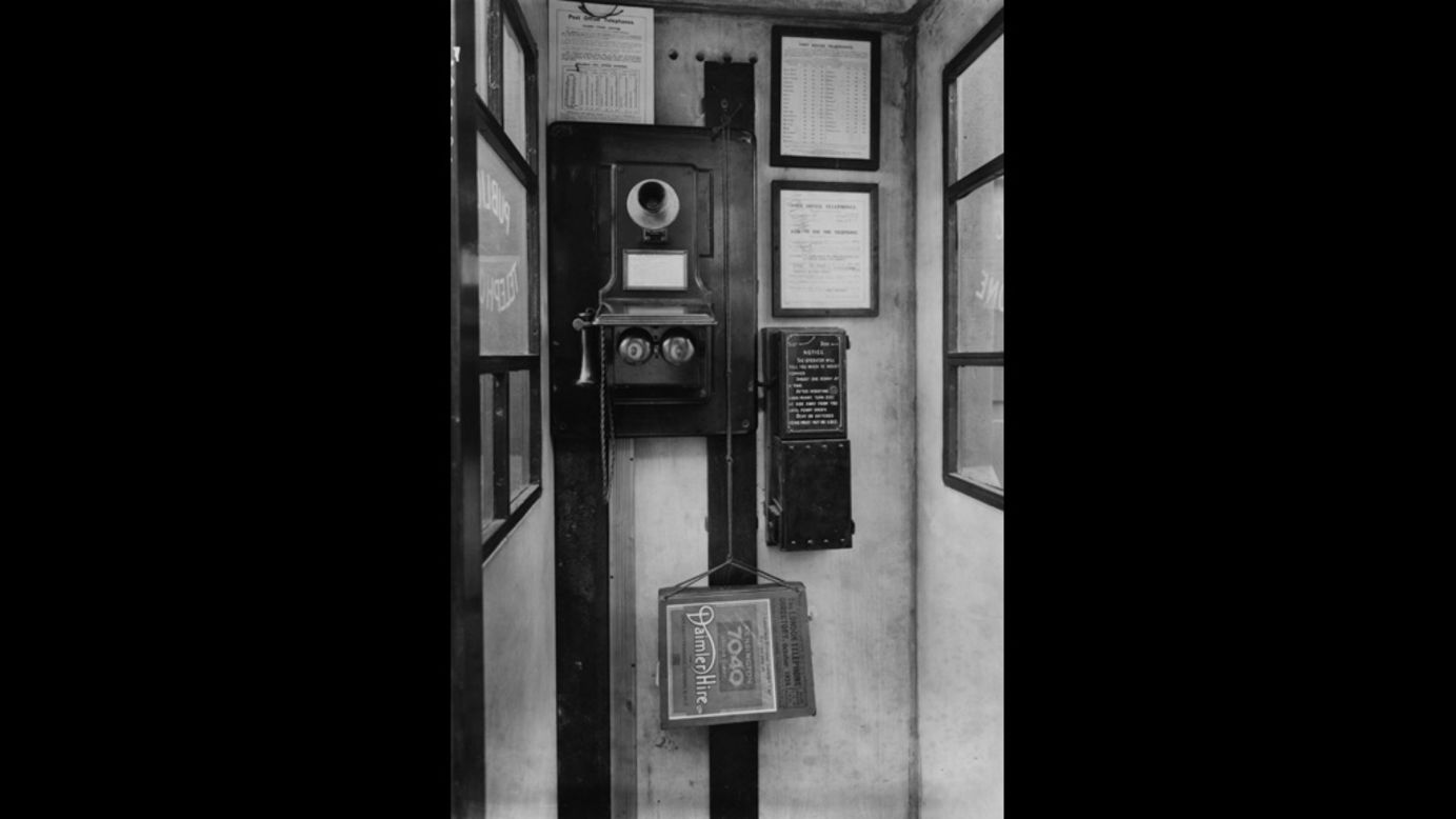 This 1924 phone booth in London features a wall-mounted phone with separate mouthpiece and receiver.