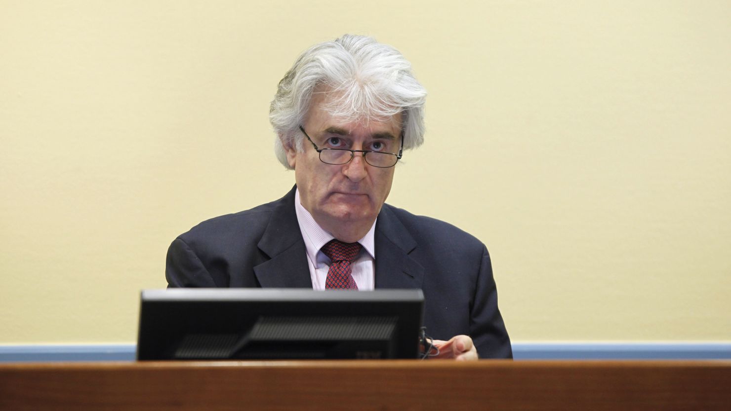 Former Bosnian Serb leader Radovan Karadzic looks up during his first court appearance since the start of his genocide trial in the courtroom of the International Criminal Tribunal for the former Yugoslavia (ICTY) in the Hague on November 3, 2009.Karadzic has refused to leave his jail cell since the trial started on October 26, saying he needs more time to review more than a million pages of prosecution evidence and the statements of hundreds of witnesses. He is charged with 11 counts of genocide, war crimes and crimes against humanity for his role in the 1992-95 Bosnian war that claimed some 100,000 lives and caused 2.2 million people to flee their homes. AFP PHOTO / ANP PHOTO / Michael Kooren netherlands out - belgium out (Photo credit should read MICHAEL KOOREN/AFP/Getty Images) 