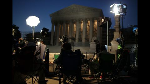 Reporters and camera crews begin waiting early Thursday outside the Supreme Court in anticipation of the court's health care ruling.