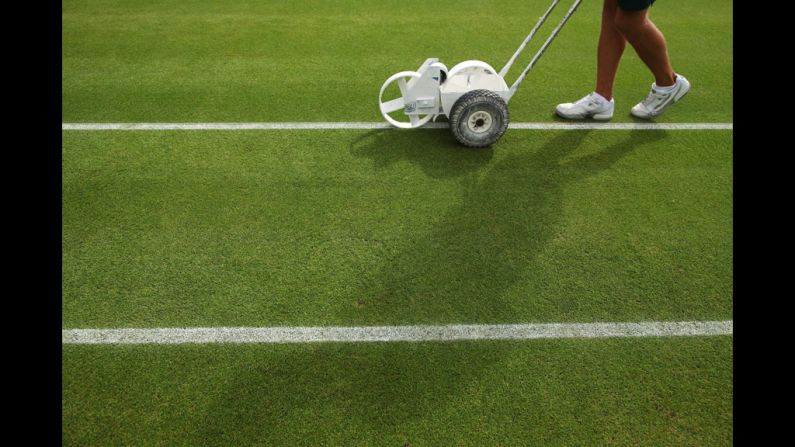 Fresh lines are painted on one of the courts at Wimbledon before the beginning of the match June 28.