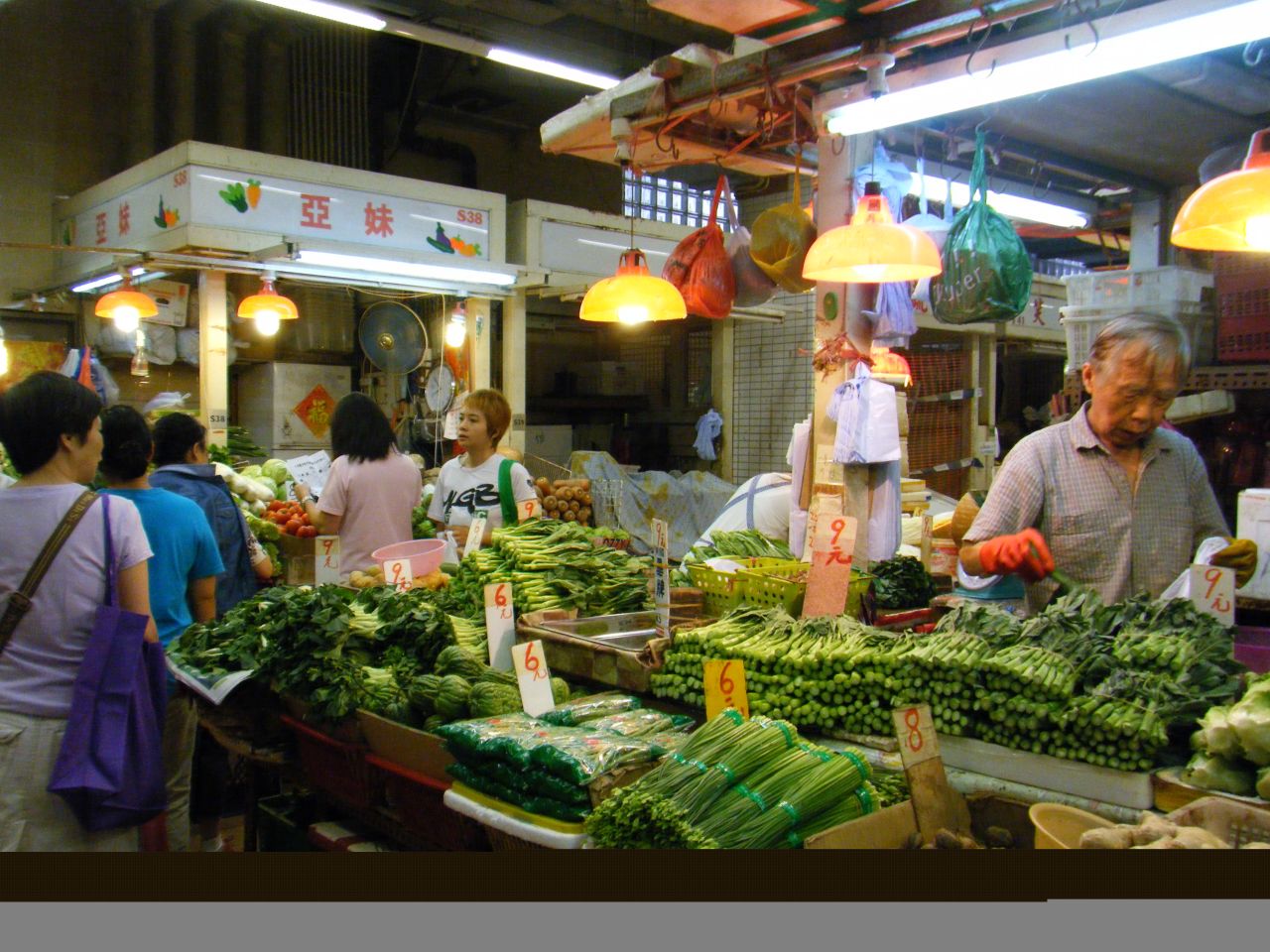 In Sai Ying Pun wet market stall holders compete for business, selling vegetables mostly imported from China. It's just a few blocks away from the central business district on Hong Kong Island.
