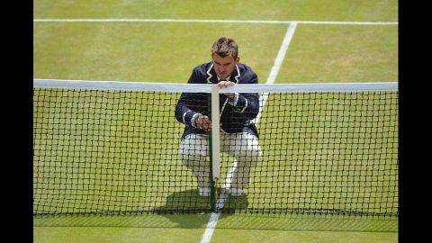 A umpire measures the height of the net on No. 2 Court on Friday.
