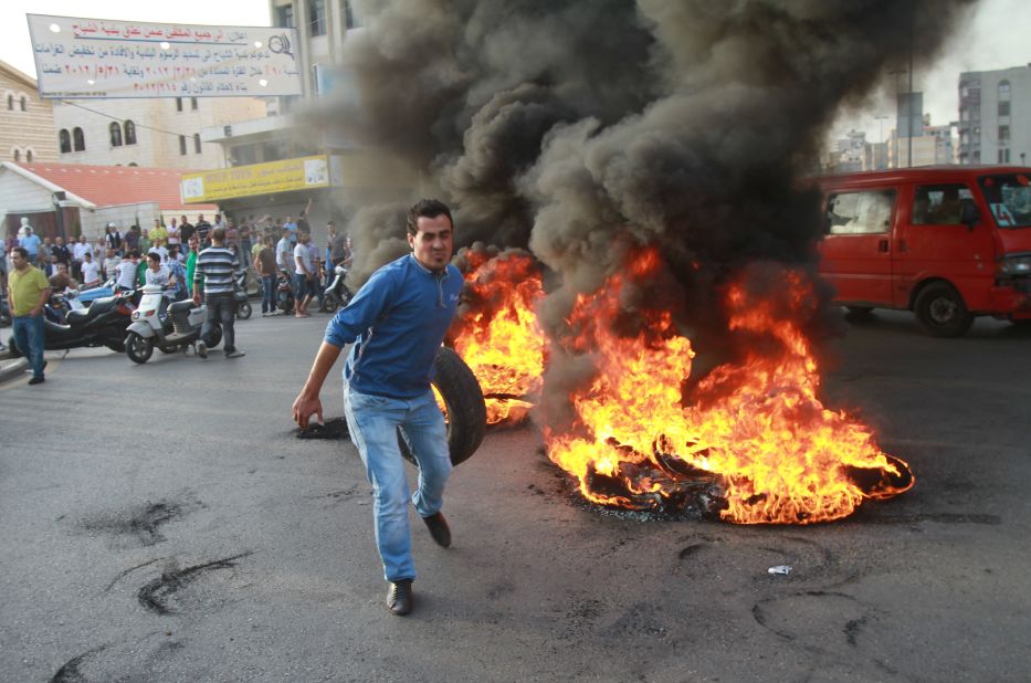 Car tires, piled and burned as roadblocks, have become a symbol of Lebanon's troubles. Pictured, youths set tires on fire in Beirut in protest against the kidnapping of Lebanese Shiite pilgrims in Syria, in May 2012.