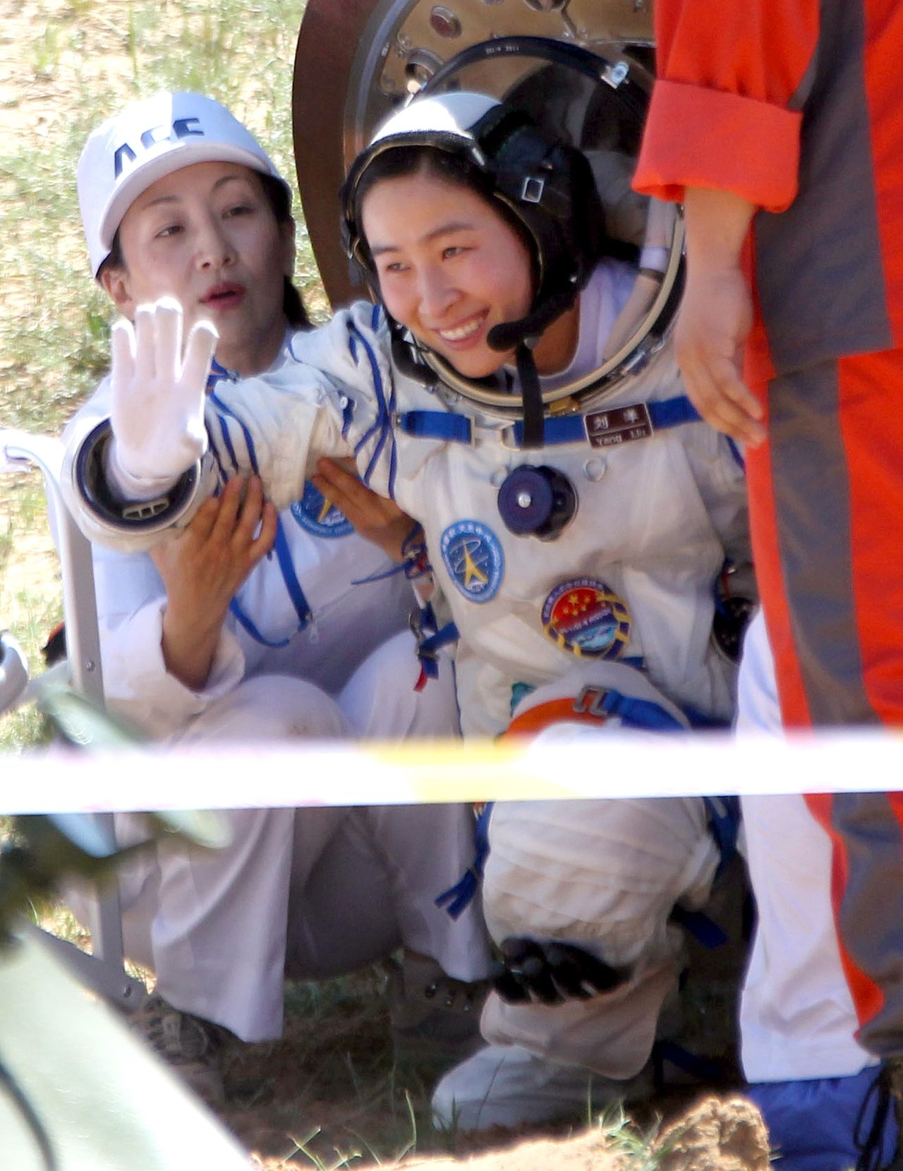 China's first female astronaut, 33-year-old Liu Yang waves as she emerges from the return capsule of the Shenzhou-9 spacecraft on June 29, 2012.<br />