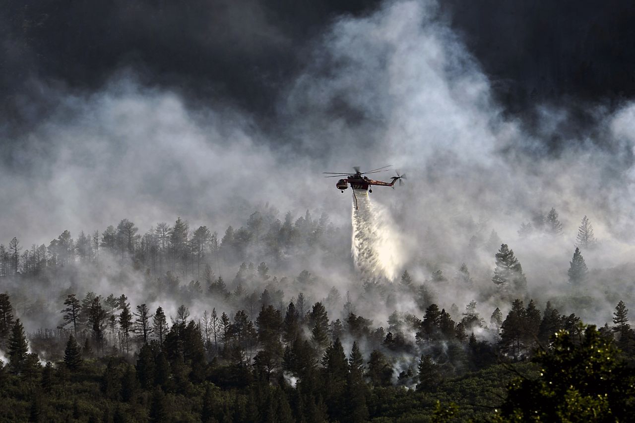 A helicopter drops water over the Waldo Canyon Fire northwest of Colorado Springs on June 27, 2012. The Western wildfires that devastated parts of Colorado, Idaho, Wyoming, Montana, California, Nevada, Oregon and Washington are expected to bring costs of about $1 billion.