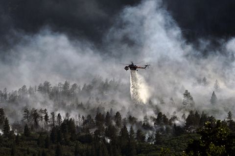 A helicopter drops water over the Waldo Canyon Fire northwest of Colorado Springs on June 27, 2012. The Western wildfires that devastated parts of Colorado, Idaho, Wyoming, Montana, California, Nevada, Oregon and Washington are expected to bring costs of about $1 billion. 