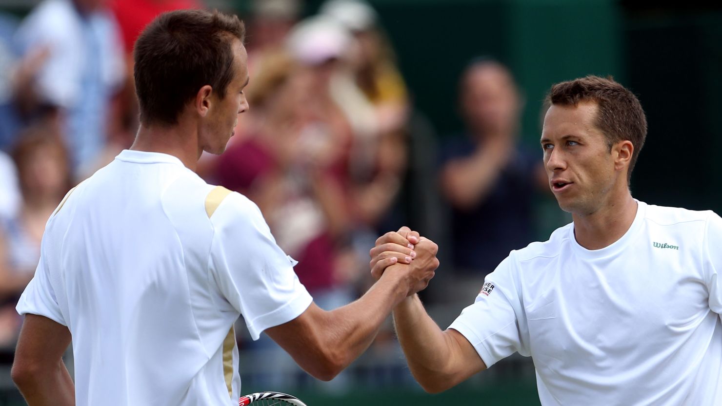 Lukas Rosol (left) shakes hands with Philipp Kohlschreiber after losing to the German in the third round at Wimbledon.