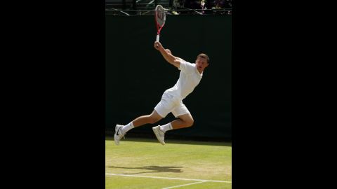 Clay Crawford of Great Britain glides through the air Saturday and returns a backhand to Yoshihito Nishioka of Japan.