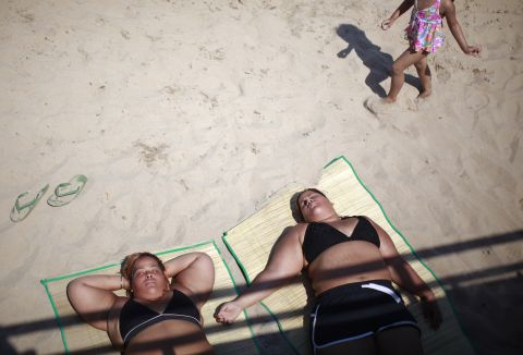 Beachgoers lie in the sun at Coney Island on Saturday.