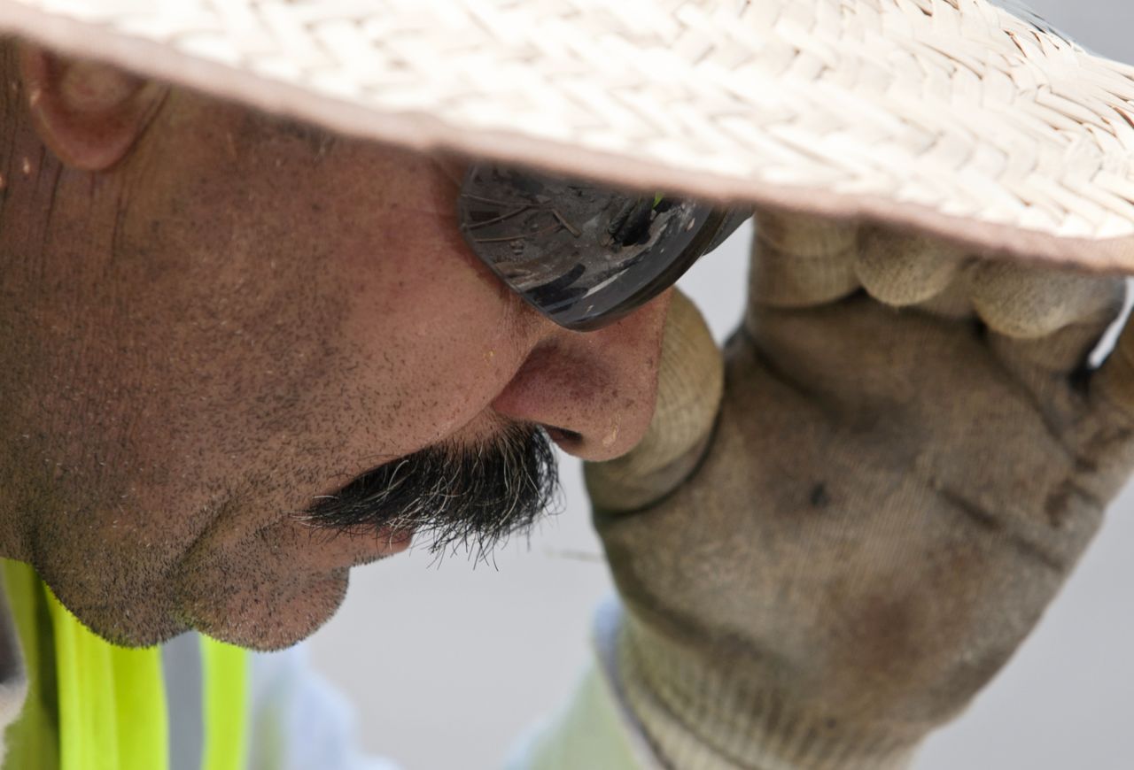 Beads of sweat roll down Francisco Hernandez's face as he works to repave Hillsborough Street in Raleigh, North Carolina, on Friday, June 29.