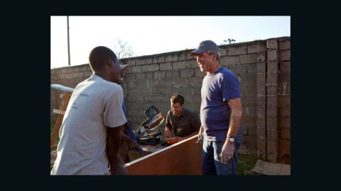 Former President George Bush helps paint and refurbish a clinic used to screen and treat cervical cancer in Kabwe, Zambia. 