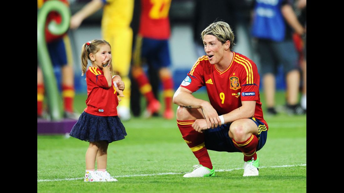 Fernando Torres of Spain speaks with his daughter, Nora, after Sunday's match against Italy.