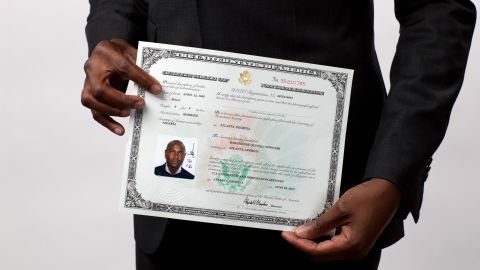 Stan Sowunmi of Nigeria displays his naturalization certificate after becoming a U.S. citizen.