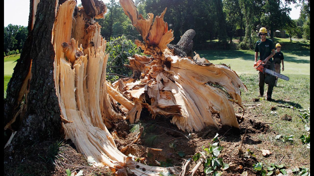 Workers cut up a tree along the 14th fairway from overnight storm damage that delayed the start of the third round of the AT&T National at Congressional Country Club in Bethesda, Maryland.