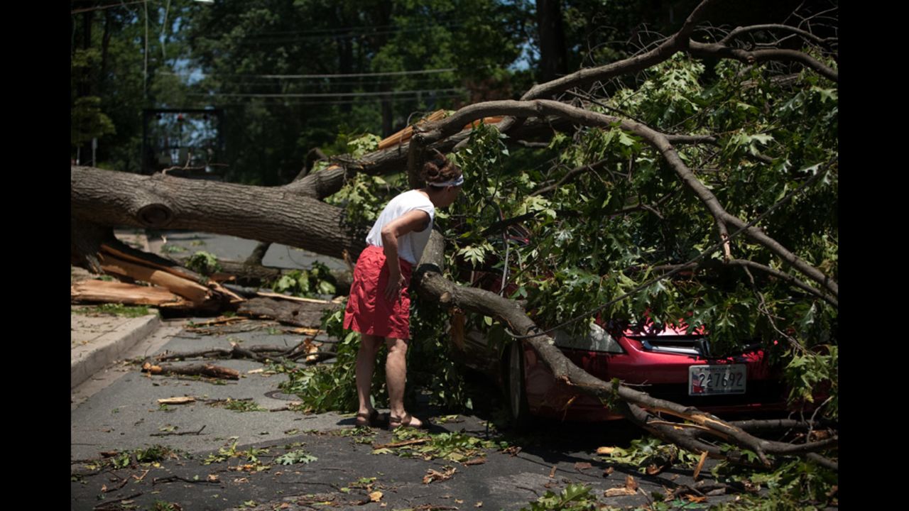 A woman inspects a car left in the middle of the road in Takoma Park, Maryland.