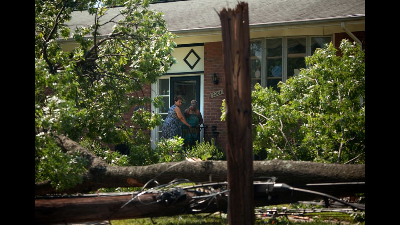 Resident Sandra Patterson, left, and friend Julia Gilliard inspect a downed tree in Patterson's front yard in Forest Glen, Maryland.