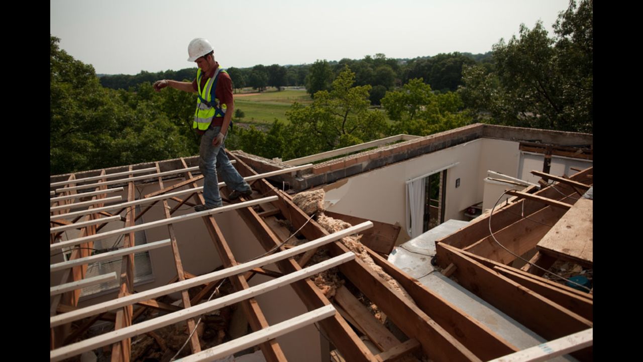 An employee of CRS Roofing walks across newly placed roof beams his company was hired to replace on the Park Tanglewood Apartments in Riverdale, Maryland.