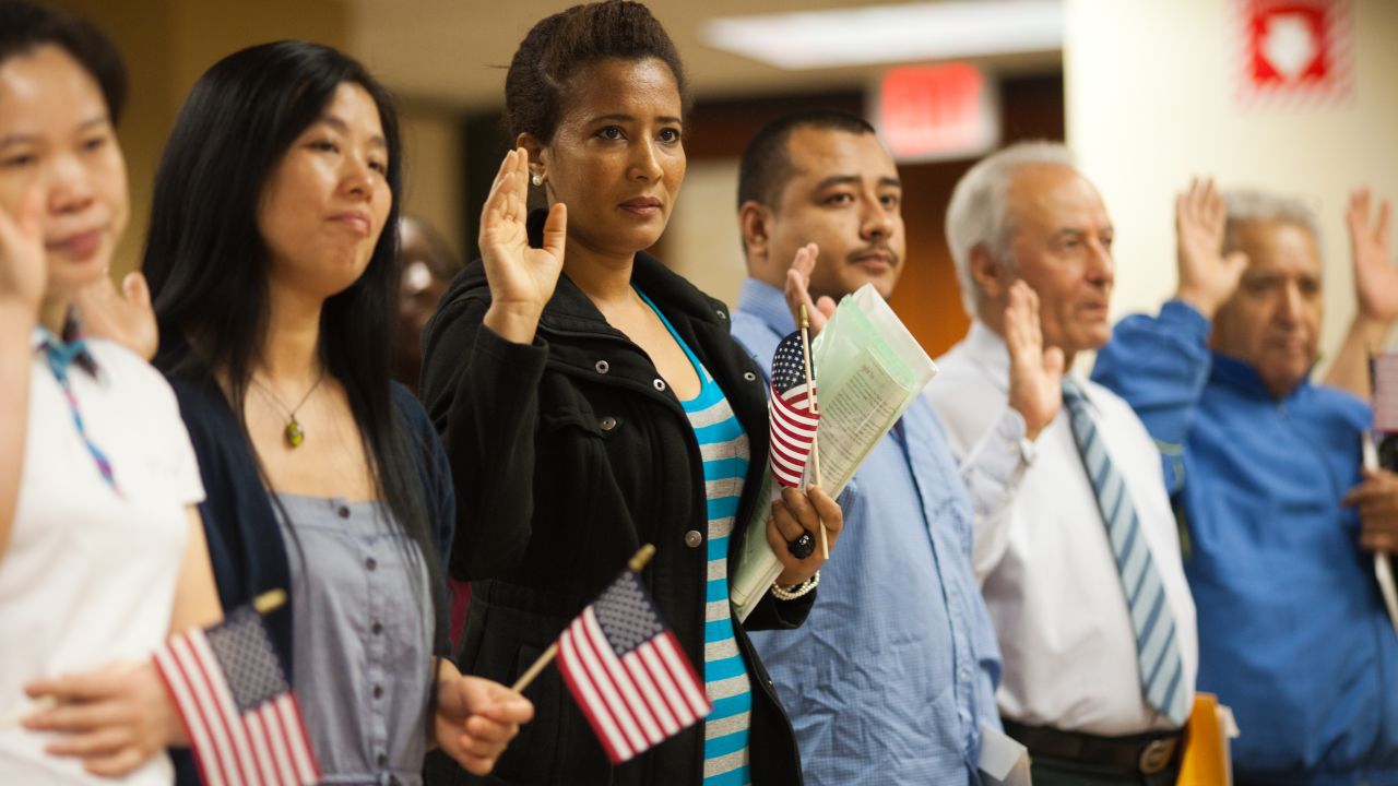 Immigrants take the Oath of Allegiance during a naturalization ceremony in Atlanta to officially become U.S. citizens.