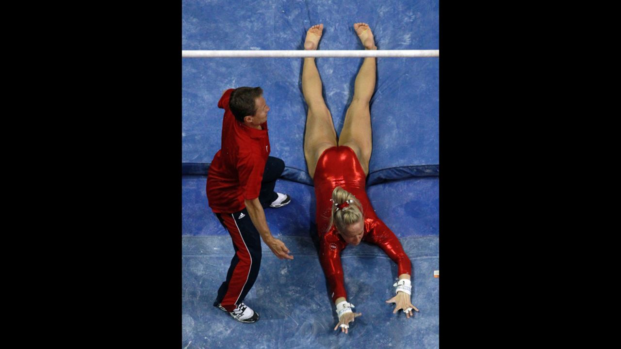 Nastia Liukin falls off the uneven bars in front of coach and dad Valeri Liukin during Day Four of the 2012 U.S. Olympic Gymnastics Team Trials.