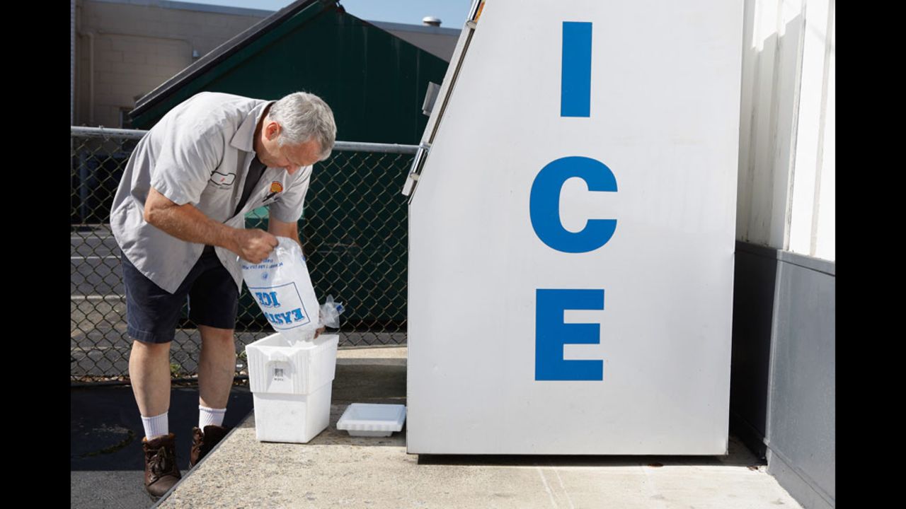 Without electricity to operate the pumps at his gas station in Silver Spring, Maryland, Ken Duckson fills a cooler with ice he cannot sell because his cash registers will not work. 