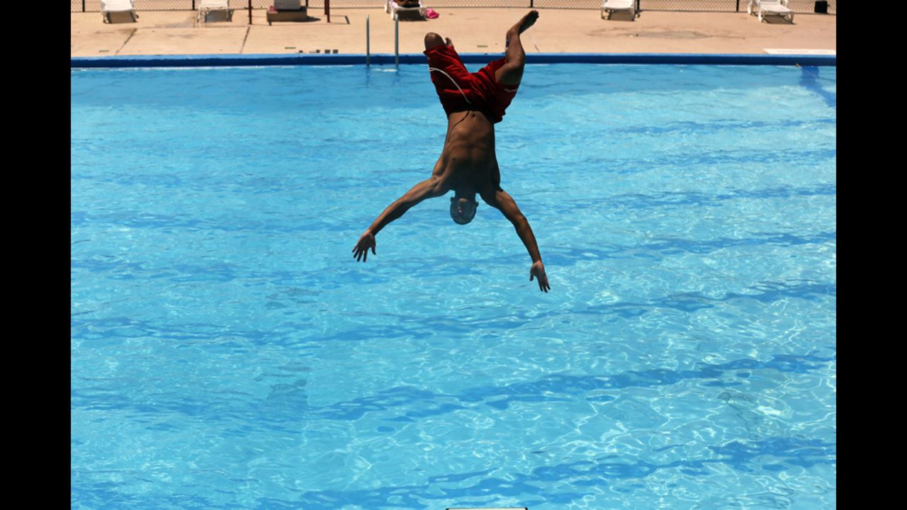 Lifeguard Niko Garcia jumps into a pool in Washington on Monday to try and beat the heat wave gripping the nation.