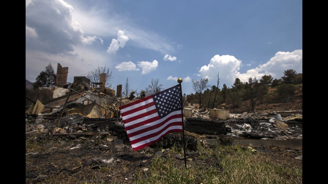 An American flag waves Monday in front of a house leveled by the Waldo Canyon Fire in Colorado Springs. Residents began returnning to the area on Sunday after the fire forced thousands of people from their homes.