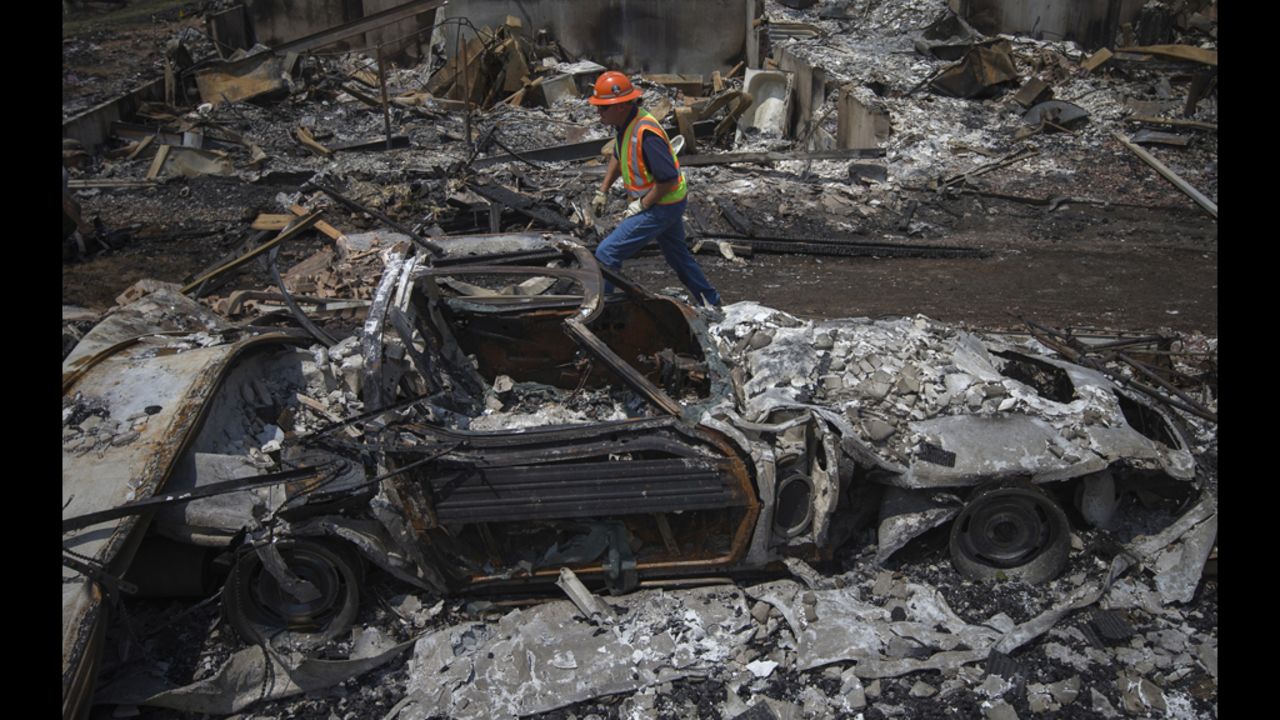 A utilities worker walks past the skeleton of a vehicle on Monday, July 2, while searching for gas leaks in a Colorado Springs community ravaged by the Waldo Canyon Fire.