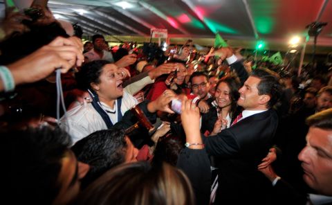 Peña Nieto greets supporters in Mexico City after polls closed and results stacked in his favor early Monday, July 2.