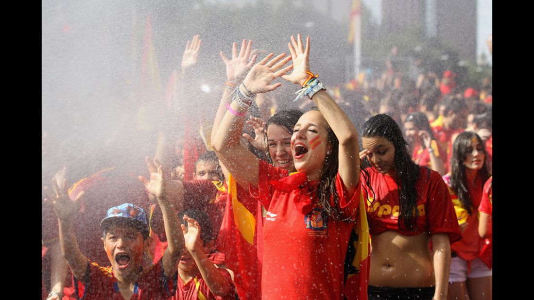 Supporters of Spain's national soccer team are hosed down before the team's victory parade in Madrid on Monday.