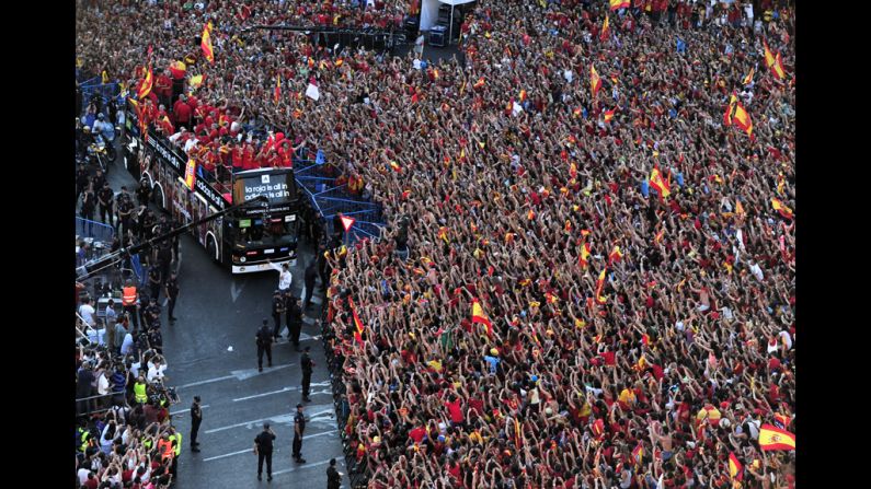 Spain's team arrives at Cibeles Square on top of a double-decker bus Monday after parading through Madrid.