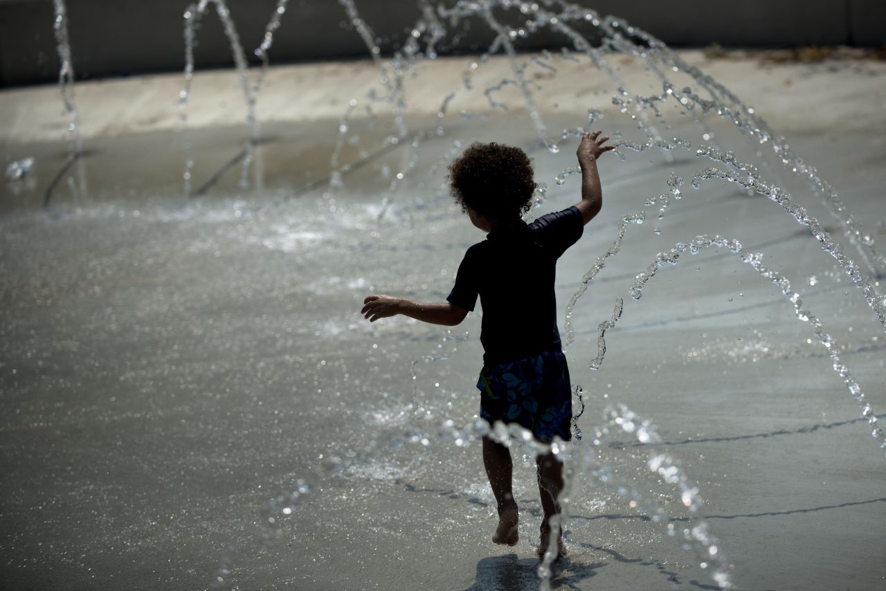 A boy plays in a water fountain in Washington on Sunday, July 1, amid a record-setting heatwave in the eastern United States.