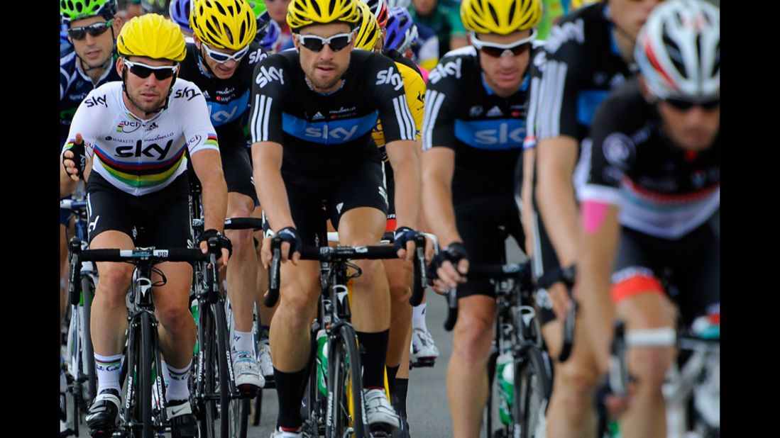Mark Cavendish, left, rides with teammates from Britain's Team Sky, wearing yellow helmets signifying their lead in the team standings.