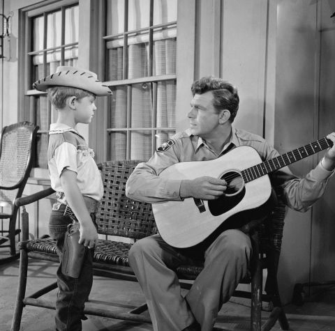 Griffith plays the guitar for his television son, Opie, during "The Runaway Kid."