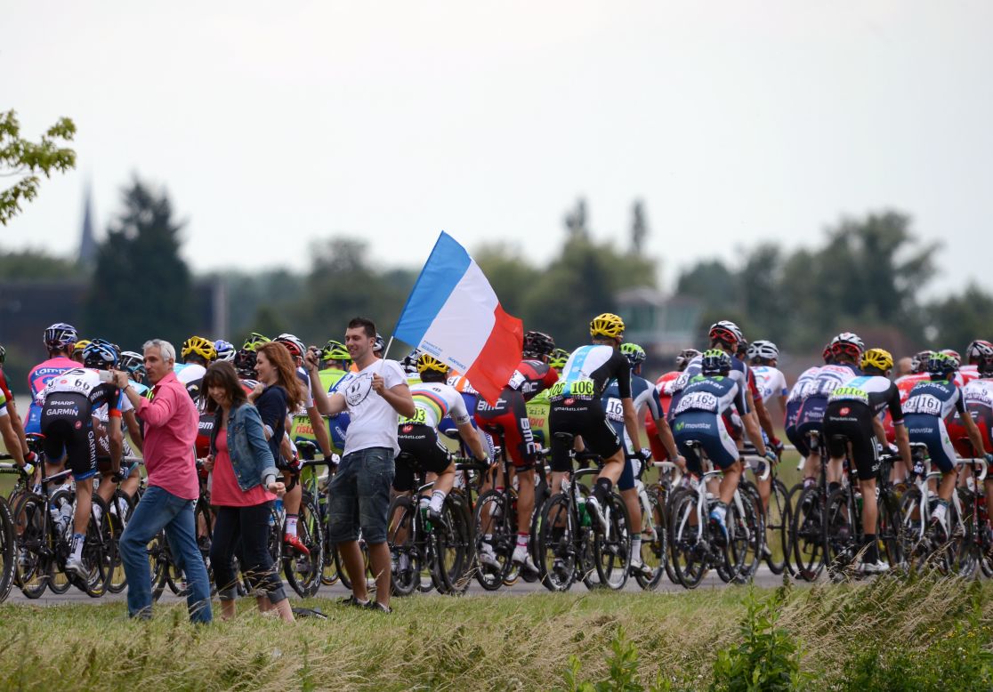 Fans wave the French flag as the peleton, led by team RadioShack-Nissan, rides past.