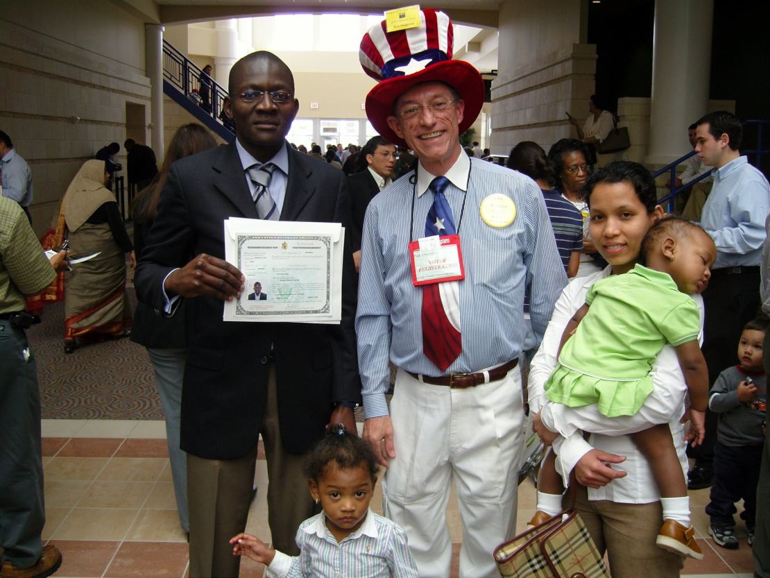 Roland Tadoum poses with a volunteer after receiving his certificate of naturalization in 2007.