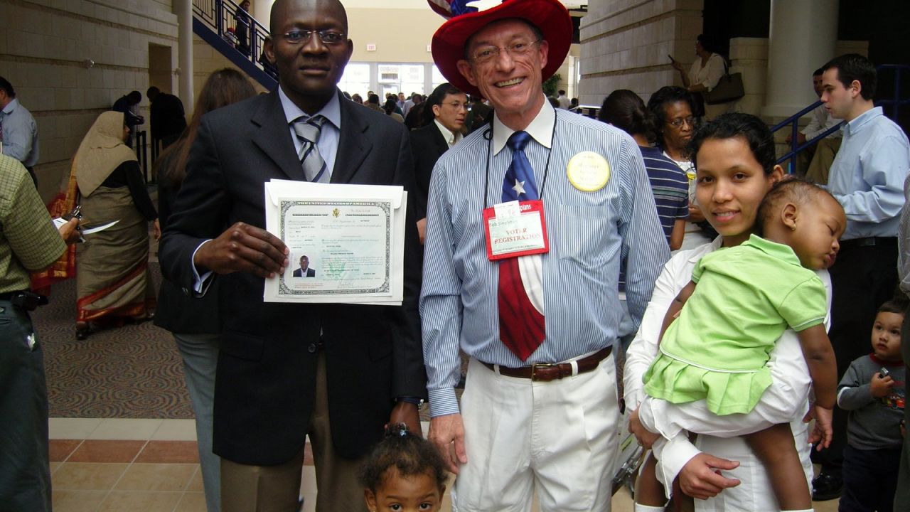 Roland Tadoum poses with a volunteer after receiving his certificate of naturalization in 2007.