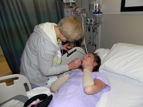 Donna Copeland applies makeup to her daughter's face as they prepare for discharge Monday. Surgeons amputated most of Aimee's hands, one of her legs and her remaining foot in an effort to stay ahead of the infection.