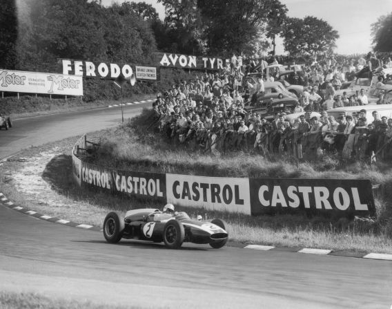 Australian racing driver Jack Brabham rounds a bend at Silverstone, featuring new raised earth banks, during the Silver City Trophy race for Formula 1 cars in August 1960.