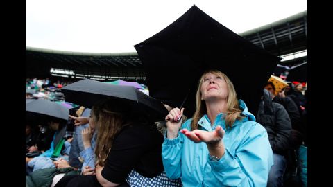 A spectator checks for rain, as rain delays halt play at the Wimbledon championships in London on Tuesday.