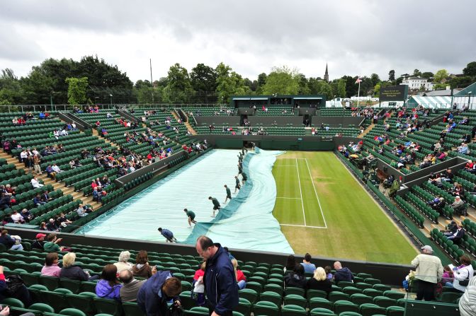 Ground staff workers remove covers from the grass before the start of the fourth round men's singles match between France's Jo-Wilfried Tsonga and Mardy Fish of the United States on Tuesday.
