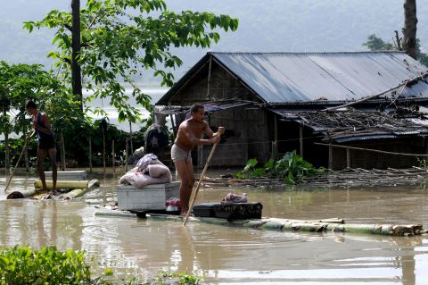 A villager moves his belongings on a banana raft from his half submerged house in floodwaters at Mayong village in Morigoan district on June 28. Prime Minister Singh has committed $90 million for relief effort.