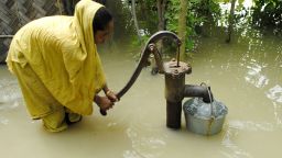 An Indian farmer pumps drinking water from well in the flood waters at Bulut Village, some 30 km away from Guwahati on June 30, 2012.