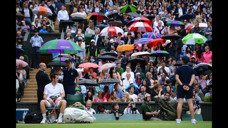 Britain's Andy Murray waits on his chair as spectators seek shelter from the rain during his men's singles quarter-final match against Spain's David Ferrer on Wednesday.