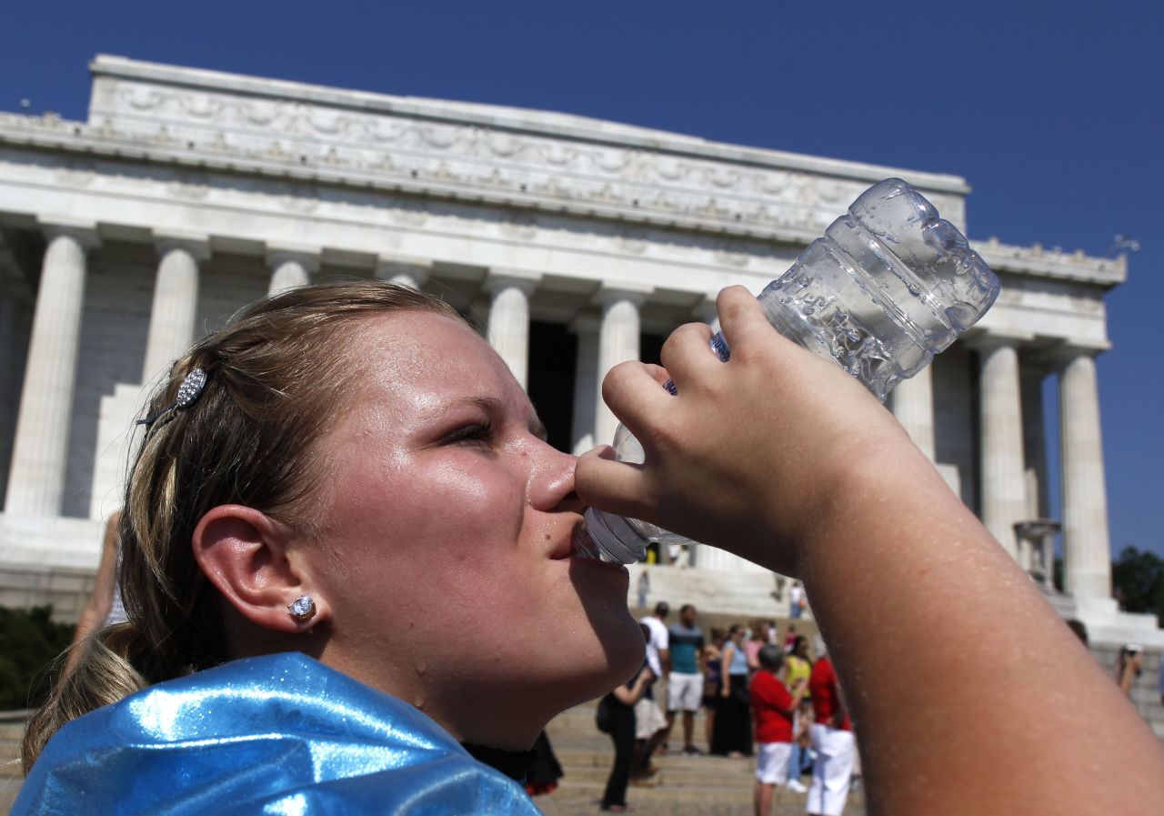 Abbi Buck, of Cookeville, Tennessee, gulps a bottle of water as sweat drips down her face as she visits the Lincoln Memorial in Washington on Tuesday.