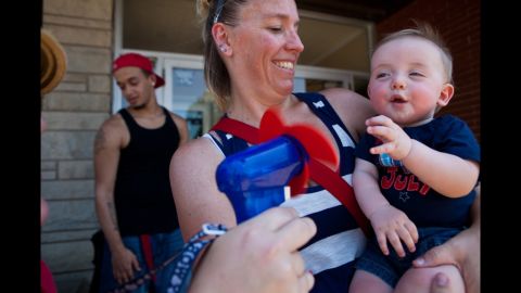 Lori Bryant holds her 7-month-old nephew Justin Tackett as Marianne Oliver cools him down during the Fourth of July parade in Downers Grove, Illinois.