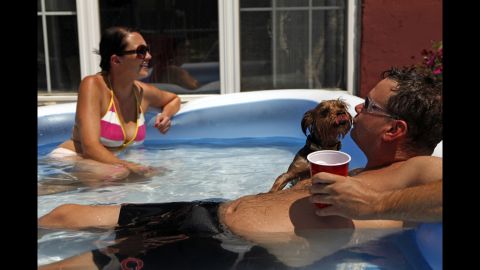 Shannon Mack and Bobby Rush keep cool with their dog, Bubba, in a pool at their apartment in Chicago on Wednesday.
