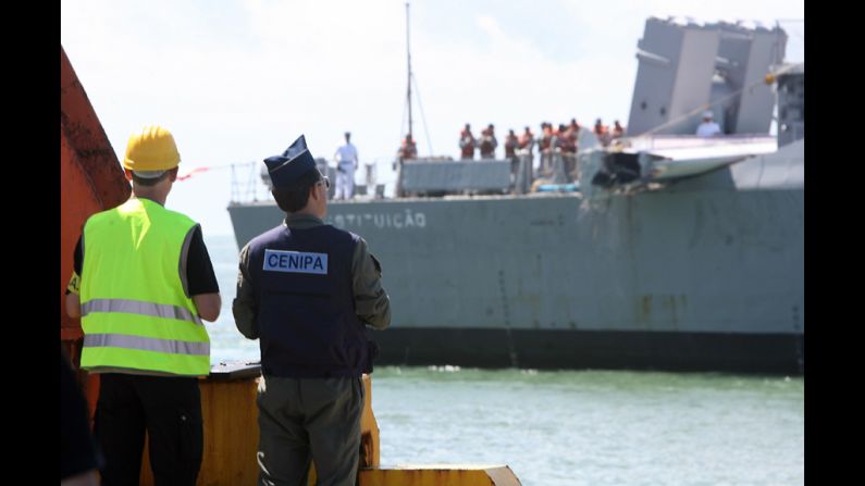 Investigators from France and Brazil wait for the Brazilian Navy frigate to unload the tailfin of the air bus.
