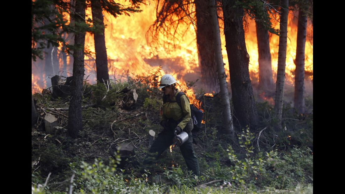 A firefighter works a burnout operation on the north flank of the Fontenelle Fire outside Big Piney, Wyoming, on Wednesday, July 4. More than 800 firefighters are working 15-hour shifts battling the fire that has exceeded 56,000 acres, according to fire information services.